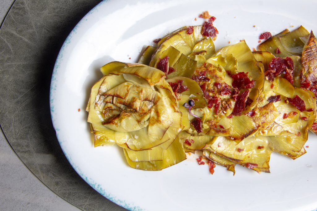 Alcachofas confitadas en flor con romescu